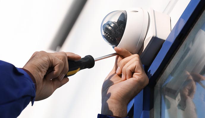 Technician installing dome camera with tester